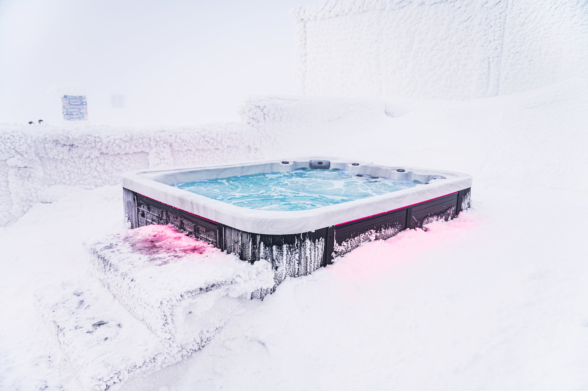 Lämmin ulkoporeallas poreilee kutsuvasti Ylläksen huipulla lumisessa ympäristössä.