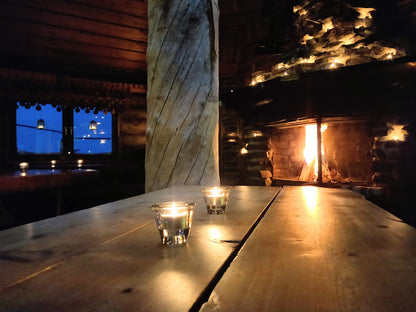 Candles illuminate the restaurant table and fireplace wall. A warming fire blazes in the fireplace.