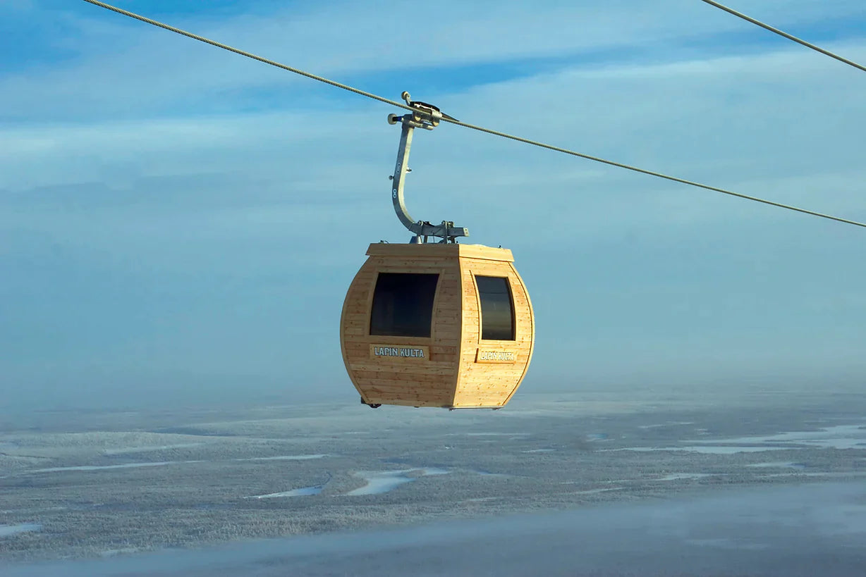 Gondola sauna running on the line through the sky. There is amazing landscape behind.