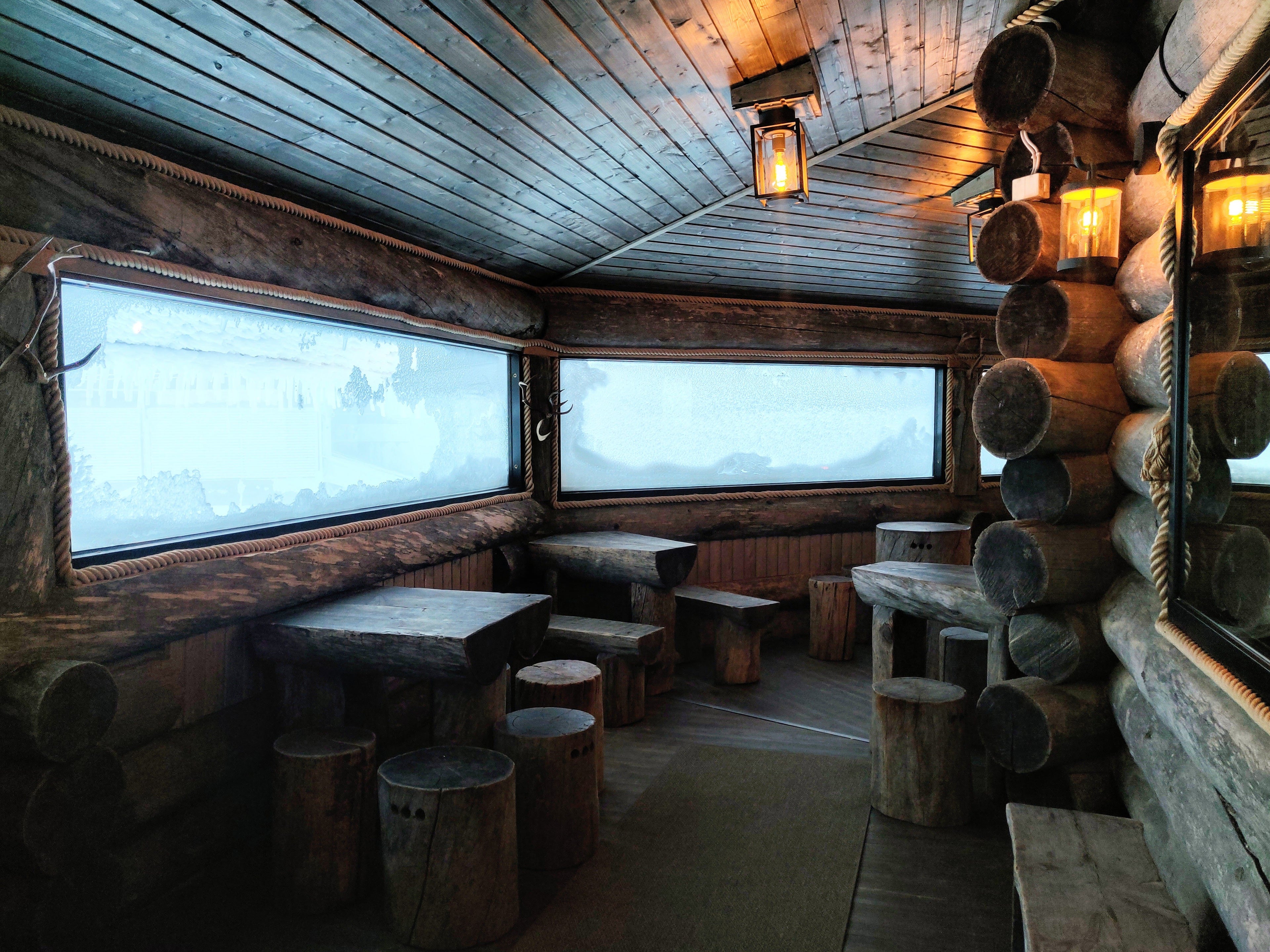 Warm terrace of restaurant Yllaskammi is cozy place with log walls, atmospheric lights and panoramic windows. 